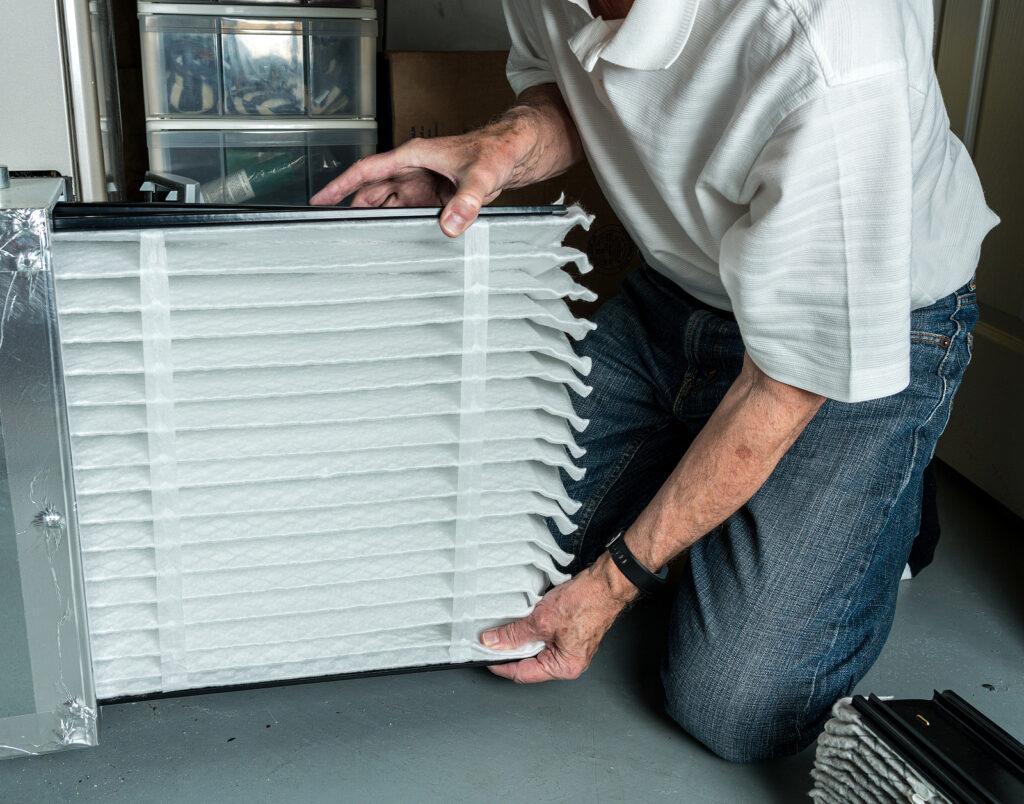 A man replacing an ac filter at home.